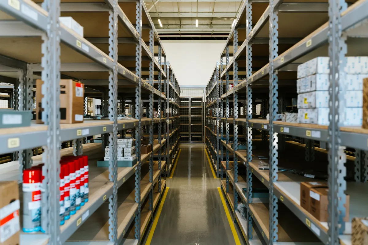 An organized warehouse aisle lined with labeled shelving.
